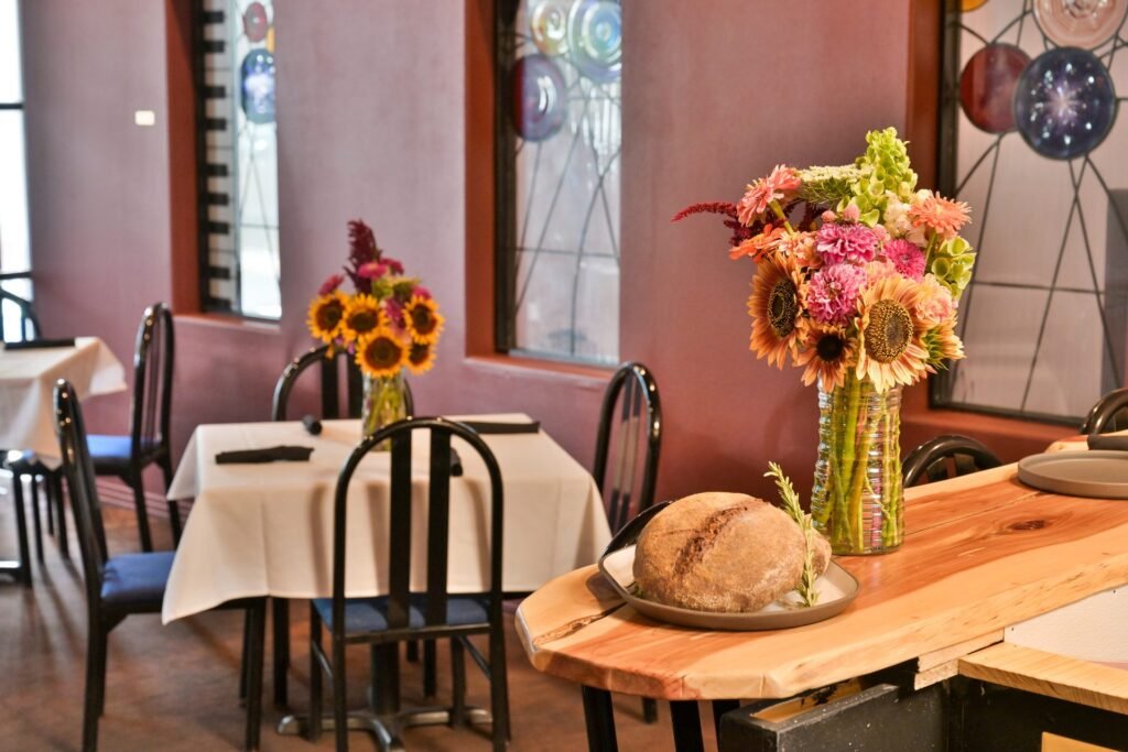 Dining room tables set with sunflowers and a live-edge counter